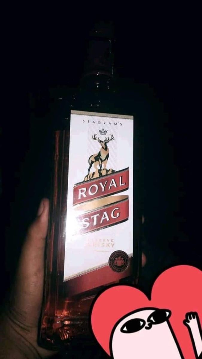 someone holding up a bottle of royal stag with a heart in the middle and an image of a dog on it