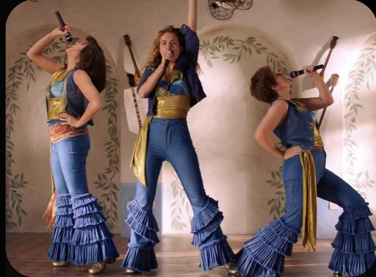 four women dressed in blue and gold dancing