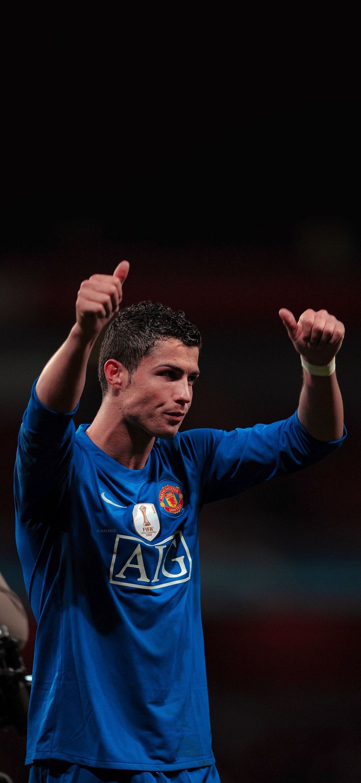 a soccer player holding his hands up in the air