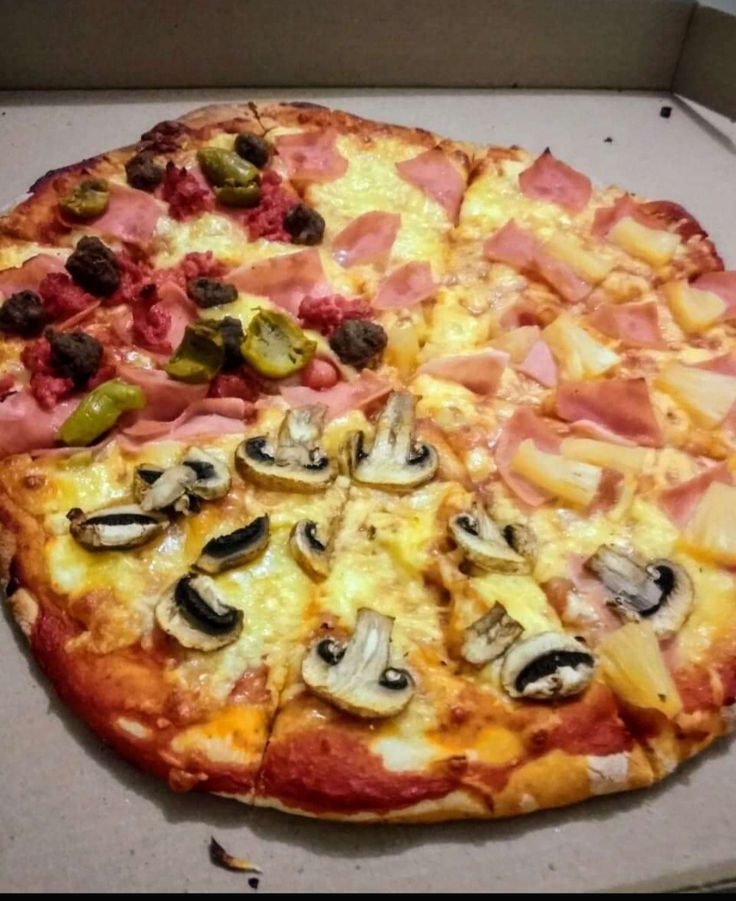 a pizza sitting on top of a pan covered in cheese and toppings with mushrooms