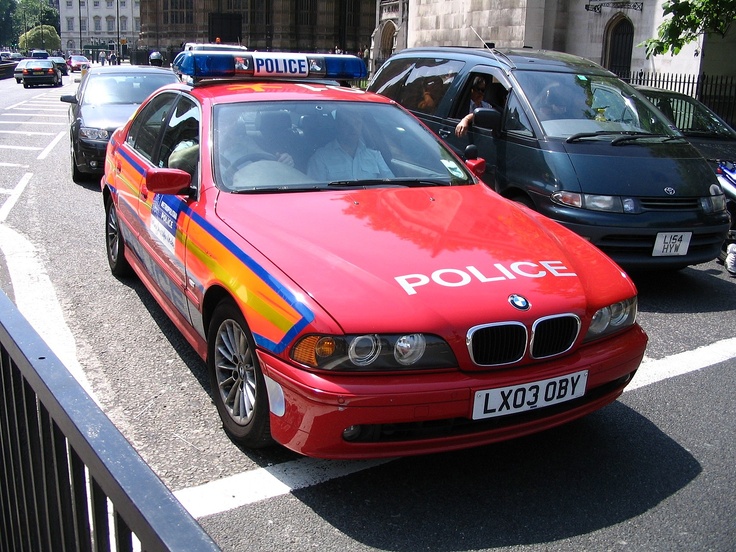 a red police car is parked on the street