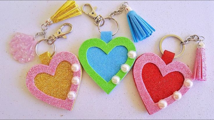 three heart shaped key chains with tassels on them