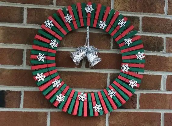 a christmas wreath made out of popsicle sticks and wrapped in tinsel with snowflakes on it