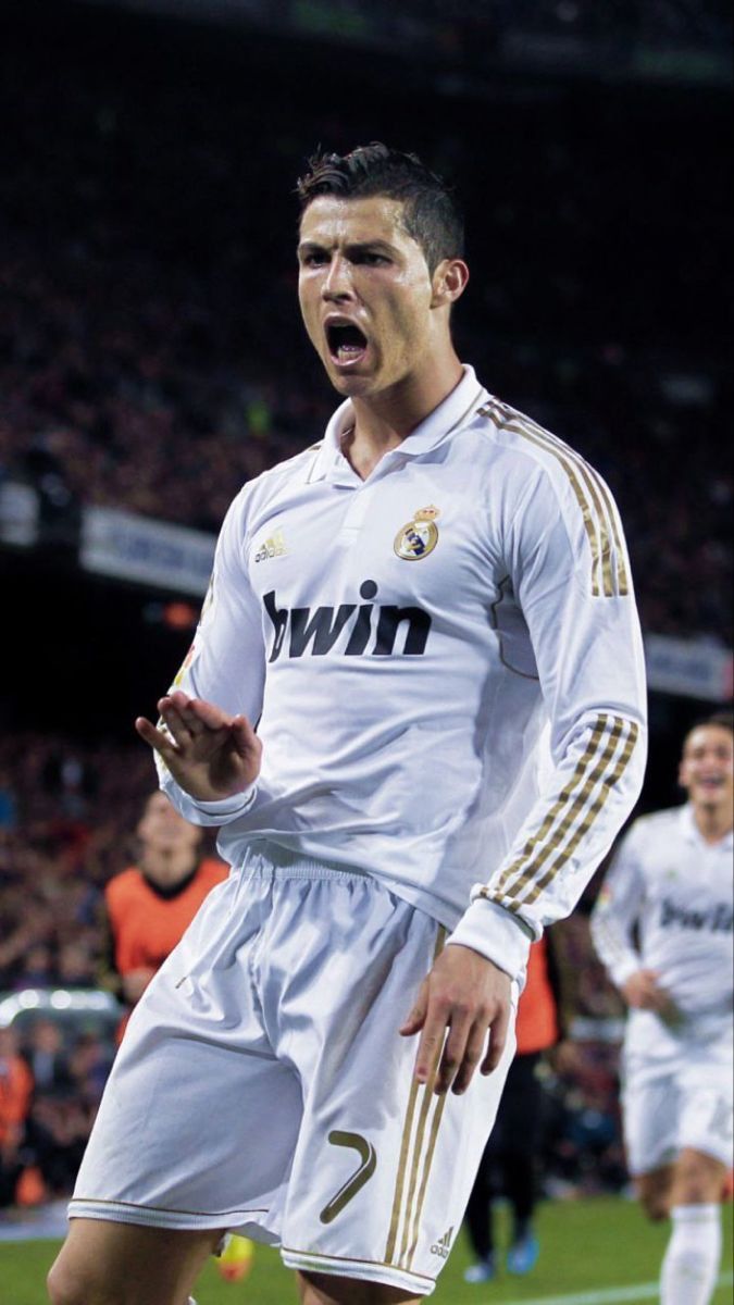 the soccer player is making a face as he walks on the field with his mouth open