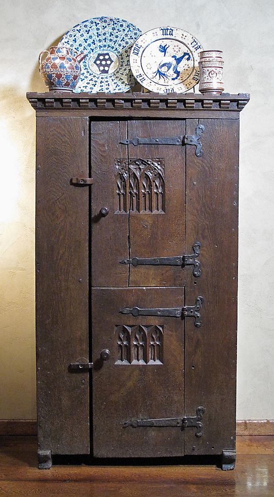 an old wooden cabinet with plates on top