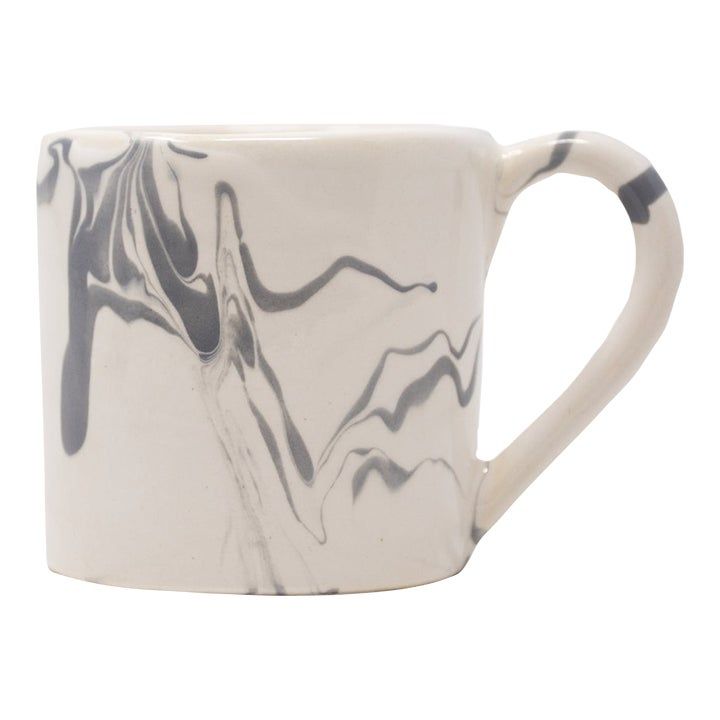 a white and black marbled coffee mug on a white background with an abstract design