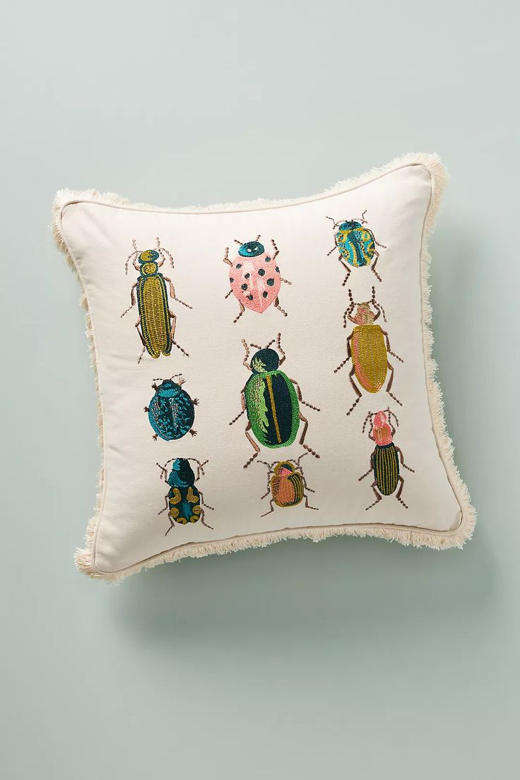 a white pillow with colorful bugs on it