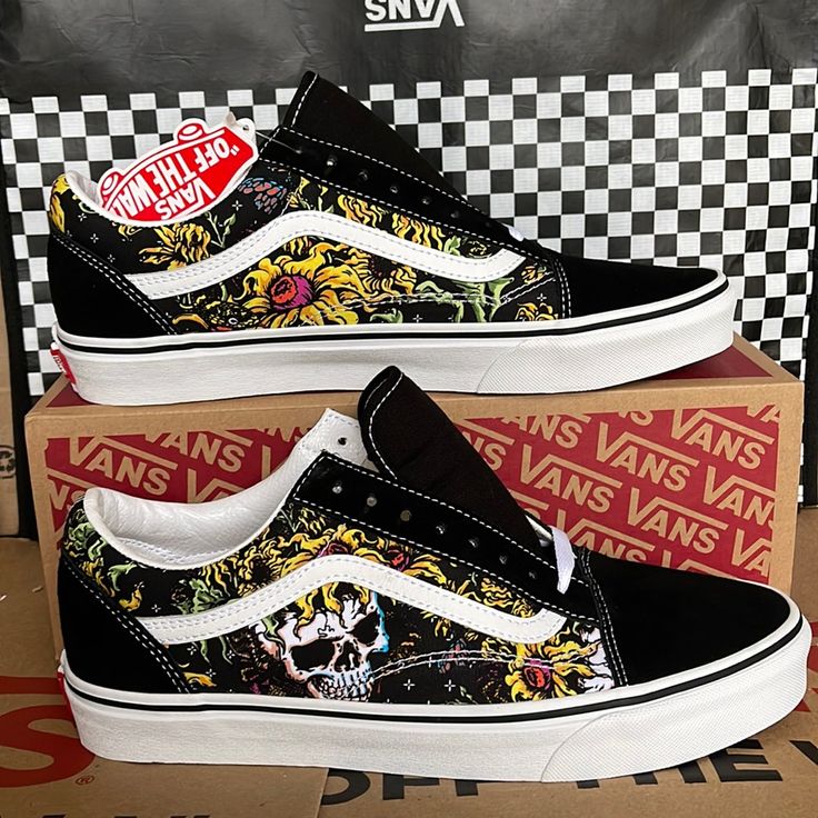 two vans shoes with skulls and flowers on them are sitting in a cardboard box next to a black and white checkerboard wall