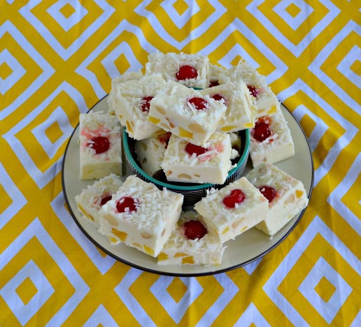 several pieces of cake on a plate with cherries in the middle and white icing