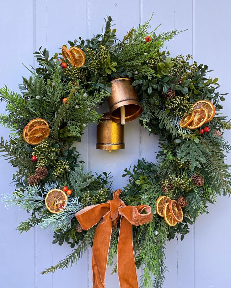 a christmas wreath with oranges, pine cones and bells