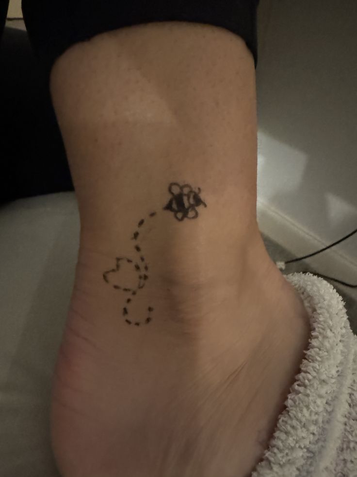 a woman's foot with a bee tattoo on her left side and the word honey written in black ink