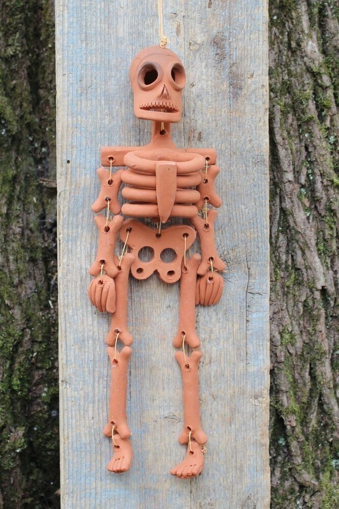 a clay skeleton hanging from a tree