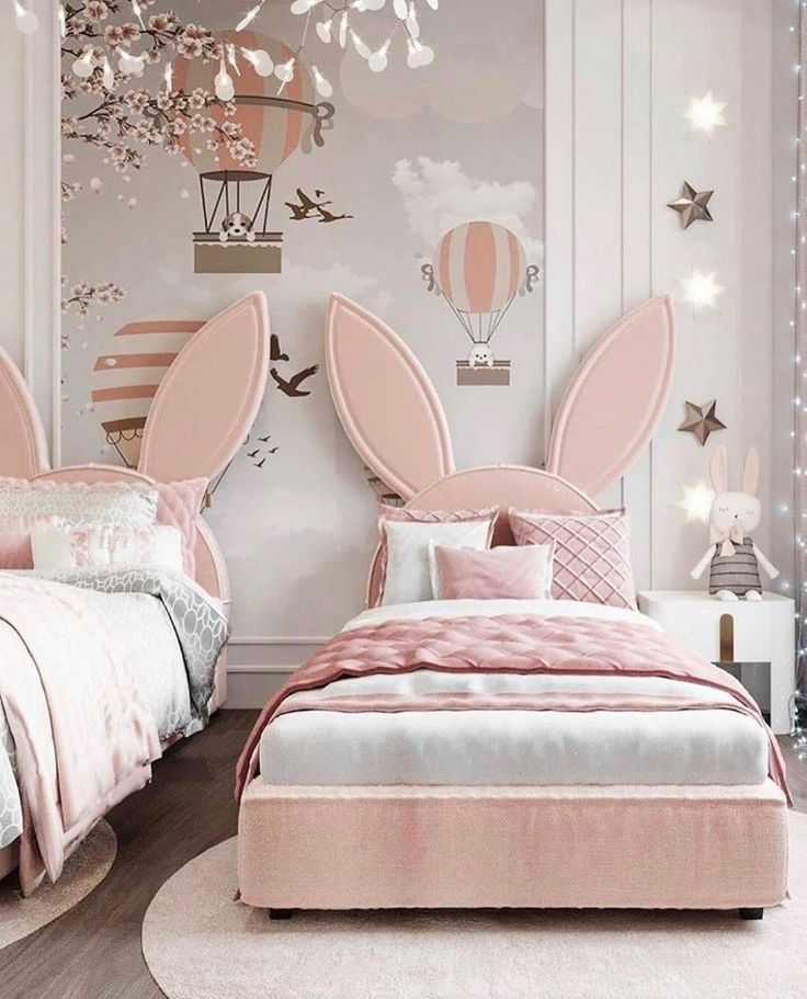 a bedroom with pink bedding and two bunny ears shaped headboards on the wall