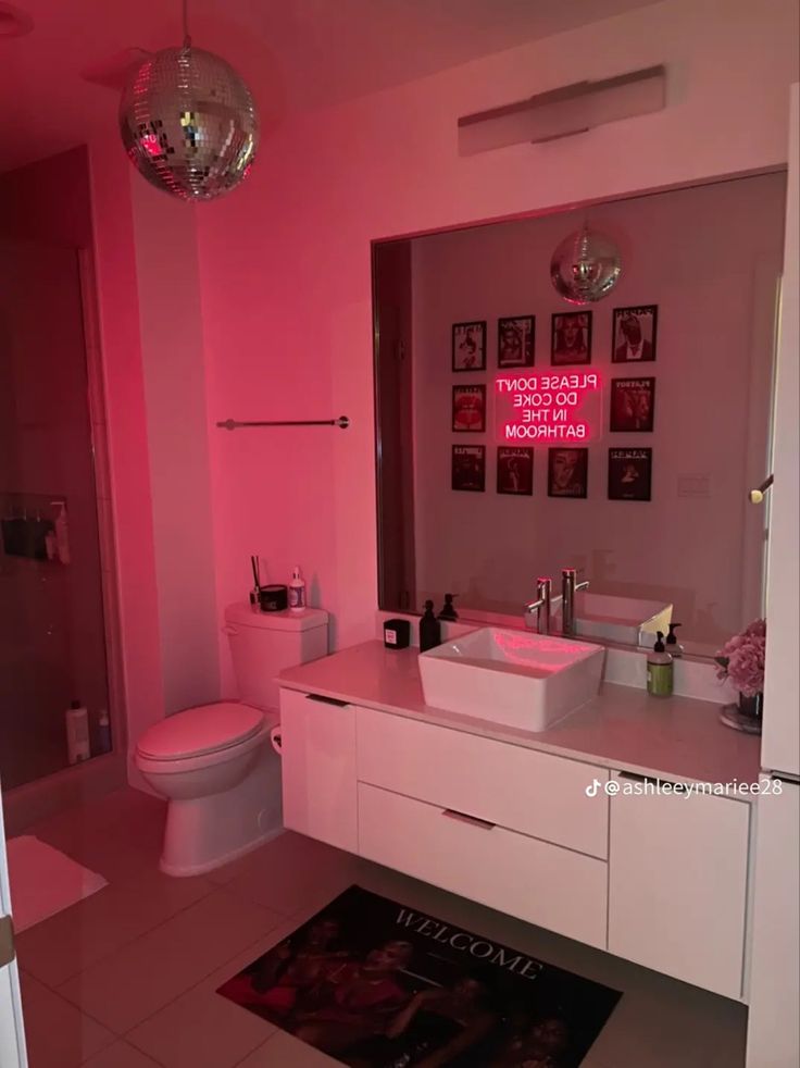 a bathroom with pink lighting and white fixtures