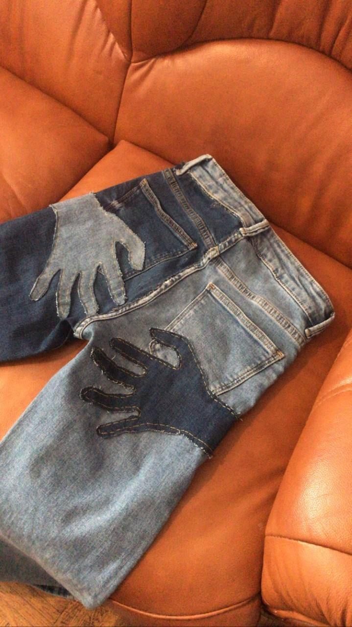 a pair of jeans sitting on top of a brown leather couch