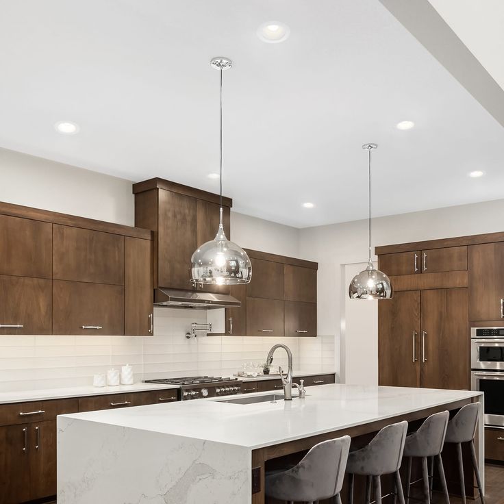 a kitchen with marble counter tops and bar stools next to an island in the middle