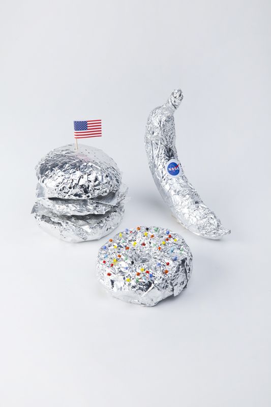 three pieces of tin foil with sprinkles and a banana sitting on top