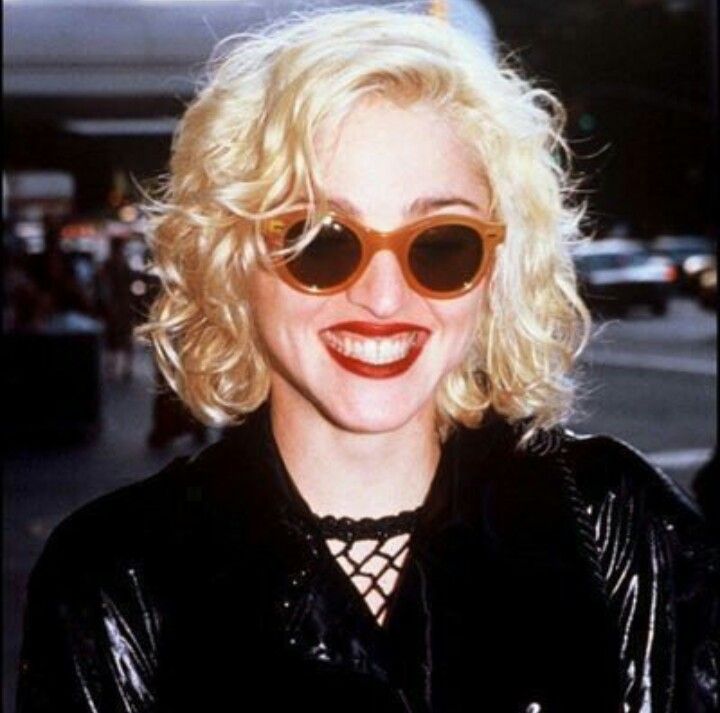 a woman with blonde hair wearing sunglasses and smiling