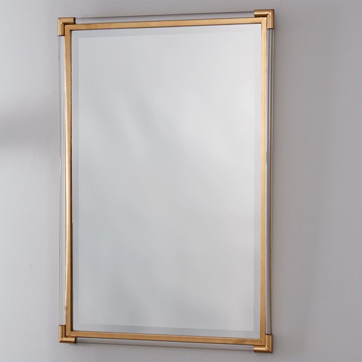 a gold framed mirror hanging on the wall