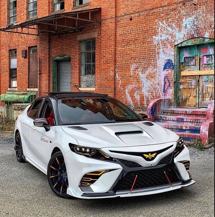 a white car parked in front of a brick building