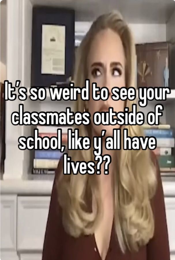 a woman with long blonde hair standing in front of a book shelf and looking at the camera