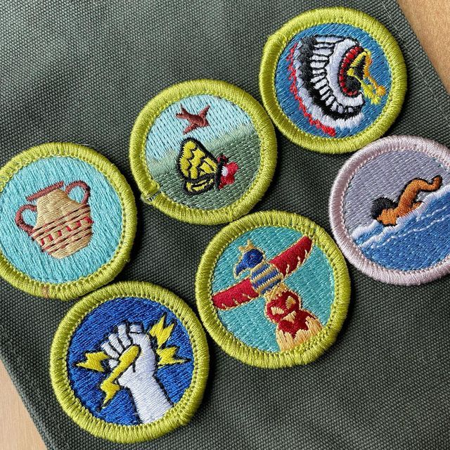 four embroidered badges with different designs on them