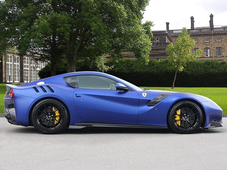 a blue sports car parked in front of a large building