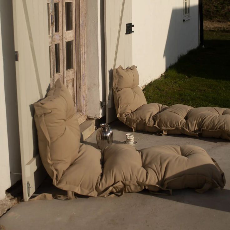 two bean bags sitting on the ground in front of an open door to a house