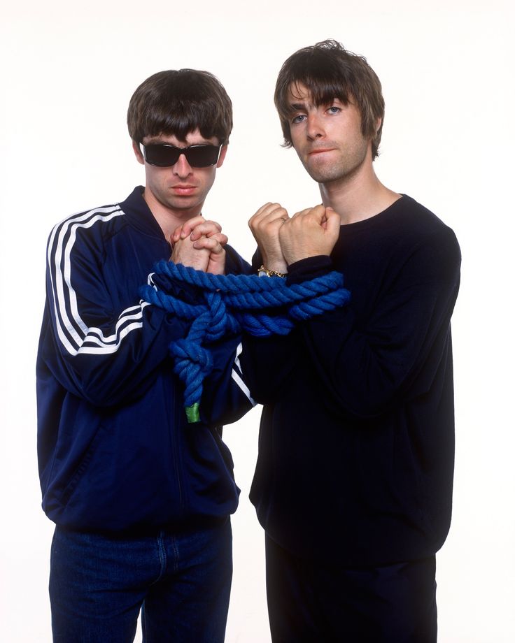 two young men standing next to each other with their arms wrapped around the neck and wearing sunglasses