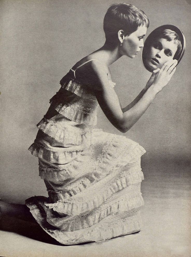 an old photo of a woman holding a mirror