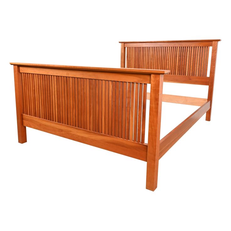 a wooden bed frame with slatted headboard and foot board on the side