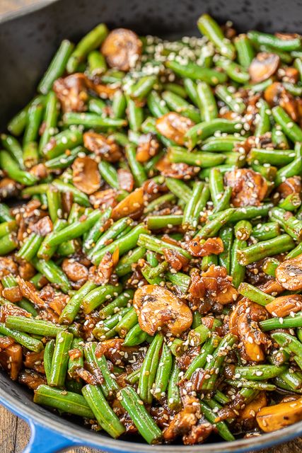 green beans with mushrooms and sesame seeds in a skillet