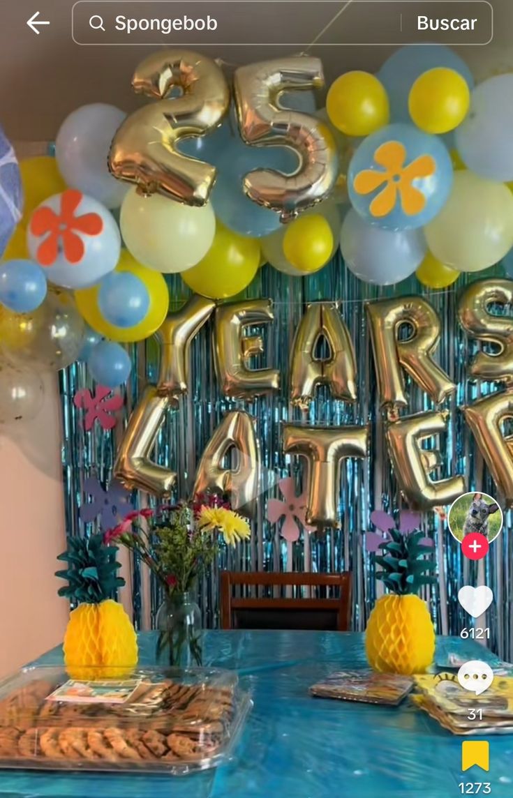 an image of a table with balloons and decorations for a party that is going on