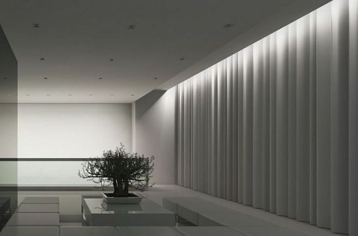 an empty room with some plants in the center and lights on either side of it