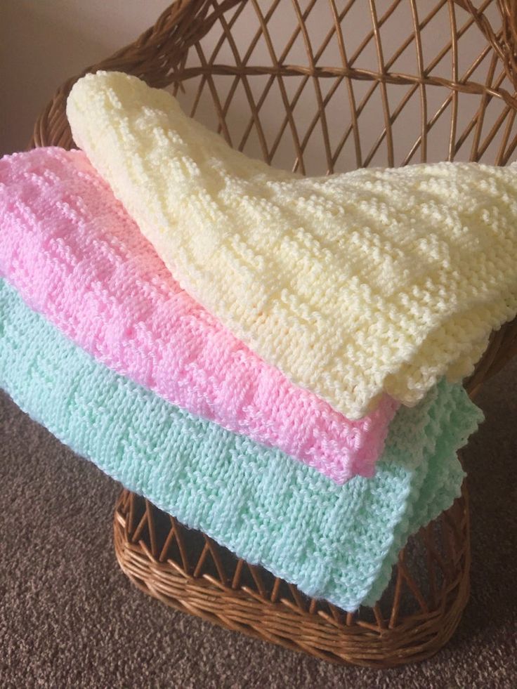 three crocheted blankets sitting on top of a wicker basket