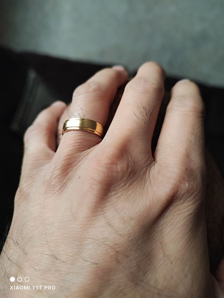 a person's hand with a gold ring on it