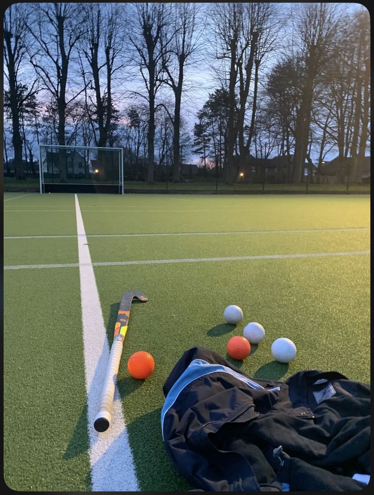 an assortment of tennis balls and equipment on the ground