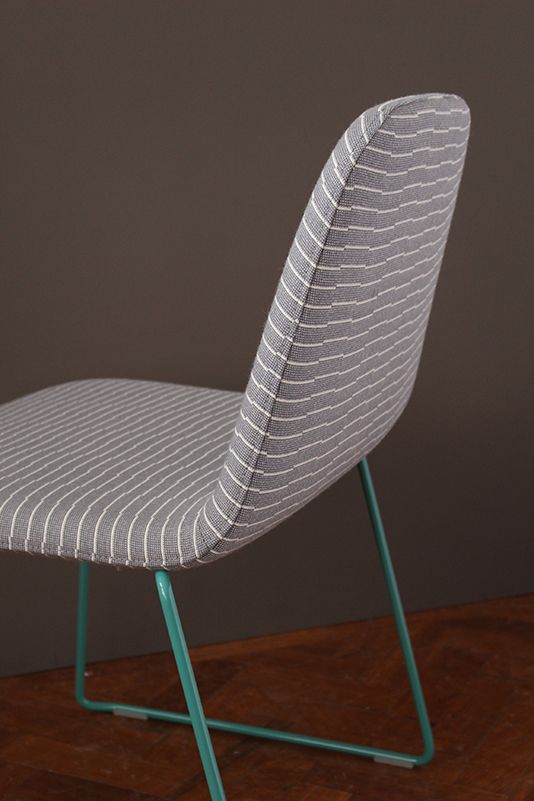 a white and blue chair sitting on top of a hard wood floor next to a wall