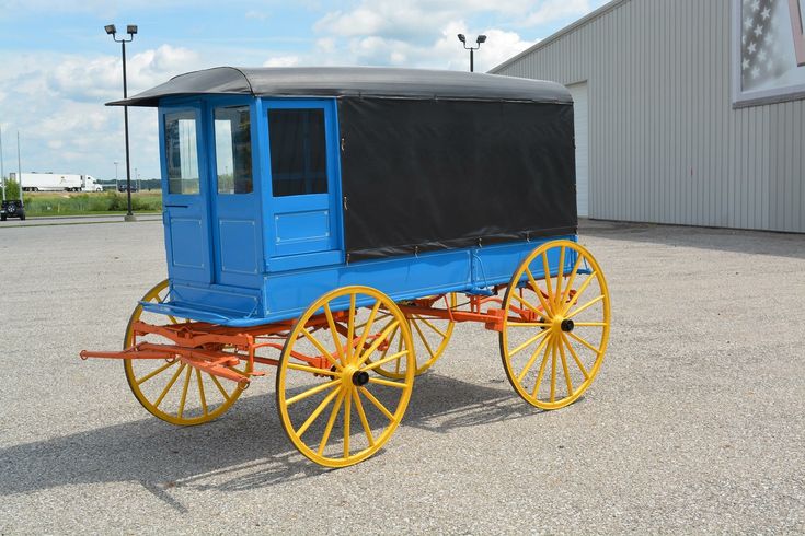 an old fashioned blue and yellow horse drawn carriage