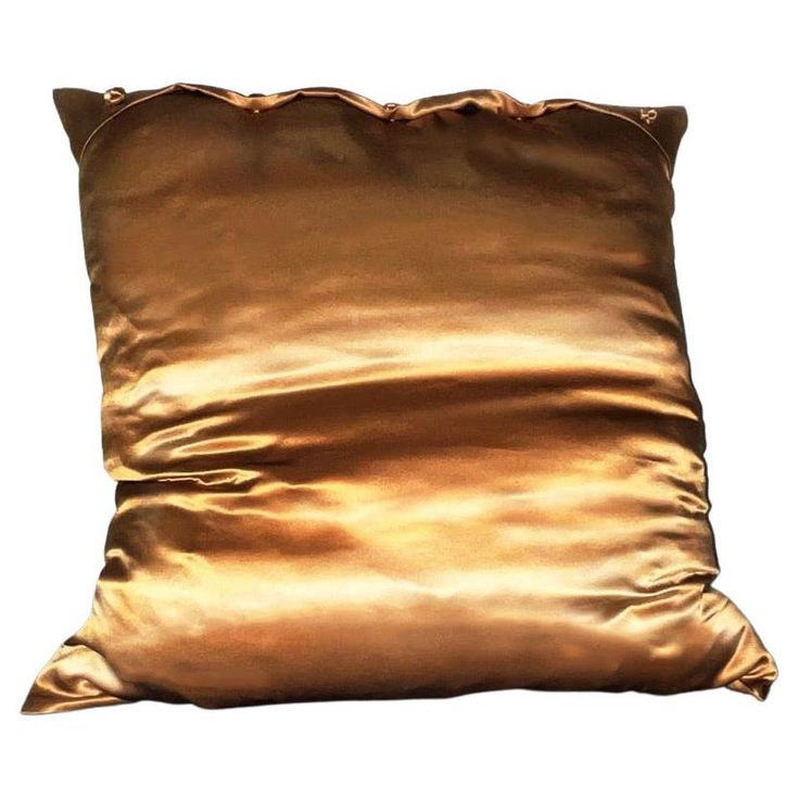 a gold pillow on a white background