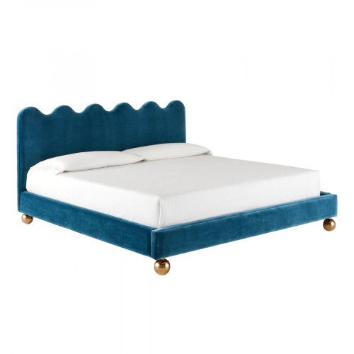 a bed with blue velvet headboard and white sheets on the bottom, in front of a white background