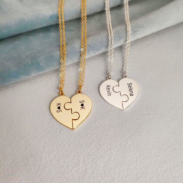 two heart shaped necklaces with puzzle pieces on them