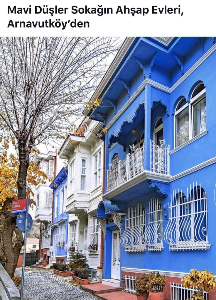 the blue building has white balconies on it