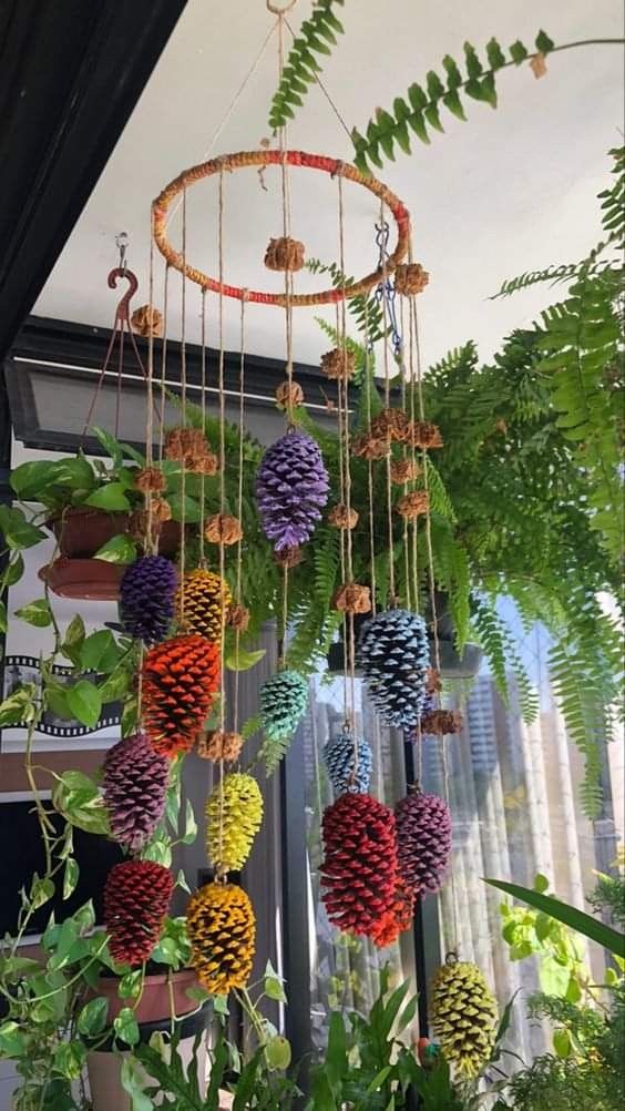 an arrangement of pinecone hanging from a ceiling in a room with plants and other decorations