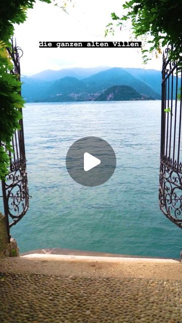 an open gate on the side of a body of water