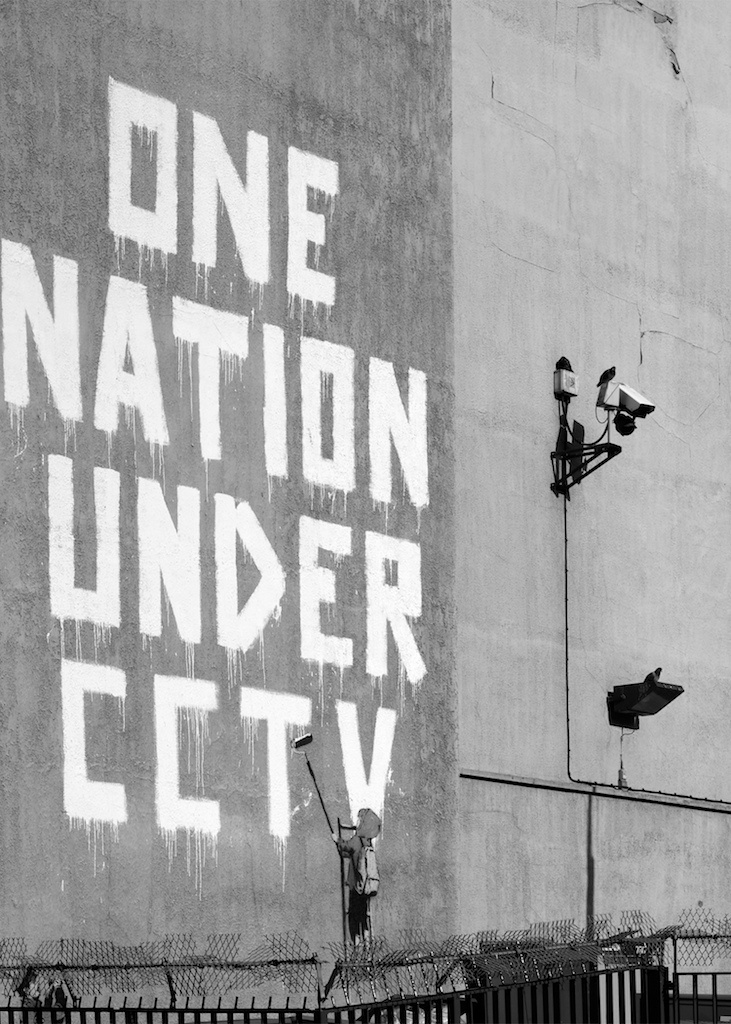 one nation under city written on the side of a building with barbed wire around it