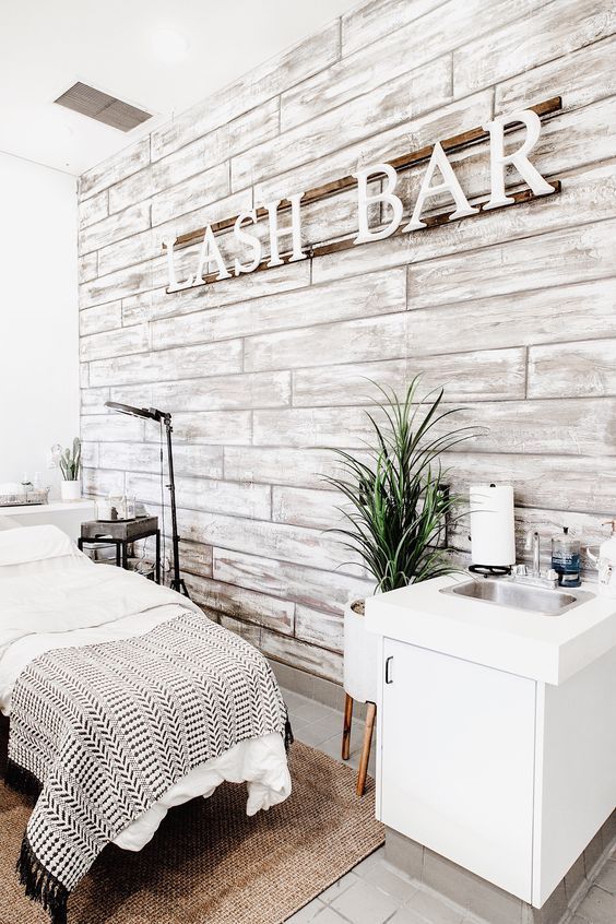 a bed sitting next to a white sink under a wooden sign that reads ash bar