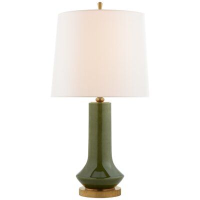 a green table lamp with a white shade on the top and gold trim around the base