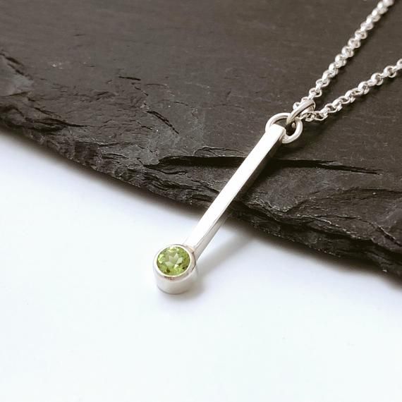 This elegant, minimal design, vertical bar peridot pendant necklace is perfect as a birthday or anniversary gift. Peridot is the traditional August birthstone. Made by hand from sterling silver, the vertical bar is 2mm x 2mm wide and 20mm long and has a round 5mm diameter tube setting at the bottom. This is set with a beautiful, fresh green, 4mm  faceted peridot gemstone. The sterling silver belcher chain (also known as a rolo chain) can be selected at your preferred length via the drop menu. Pl August Birthstone Necklace, Sterling Silver Bar Necklace, Vertical Bar Necklace, August Birthday, Silver Bar Necklace, Peridot Pendant, Vertical Bar, Peridot Necklace, August Birthstone