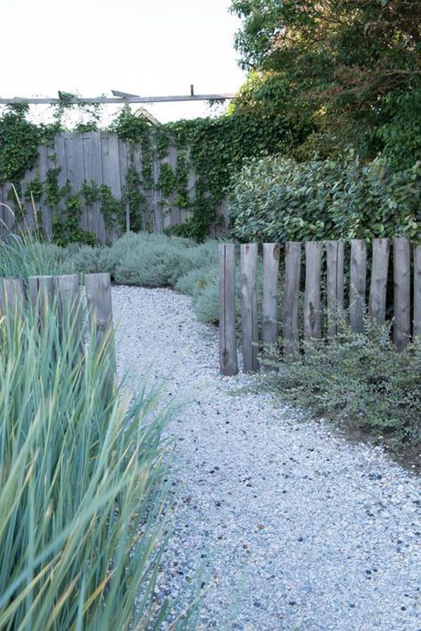 a gravel path between two wooden fences